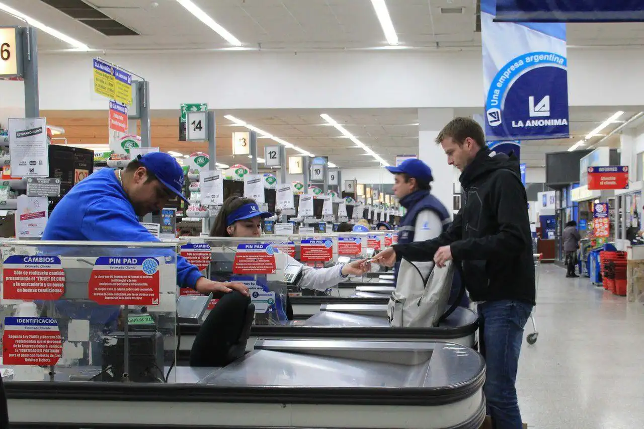 Interior de un Supermercado La Anónima con empleados trabajando y clientes comprando