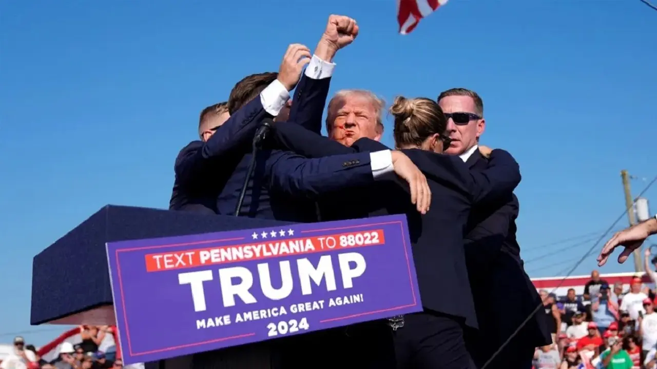 Trump siendo evacuado por sus guardaespaldas luego de recibir un tiro en su oreja derecha