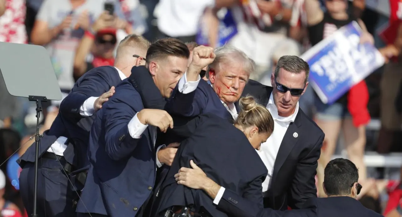 Tras el disparo que rozó su oreja, Trump se reincorporó y levantó su puño apretado ante sus militantes.