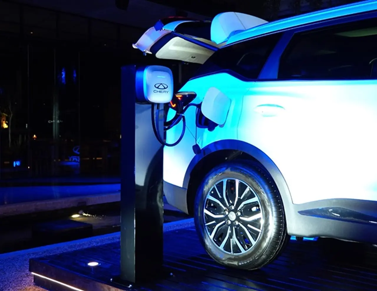 Parte trasera de un auto chery blanco iluminado por un reflector