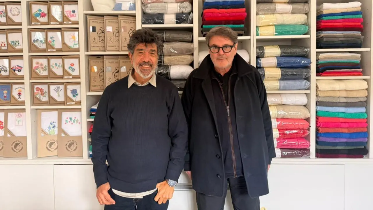 José Ini y Adolfo Setton posando con una estantería llena de productos de la empresa