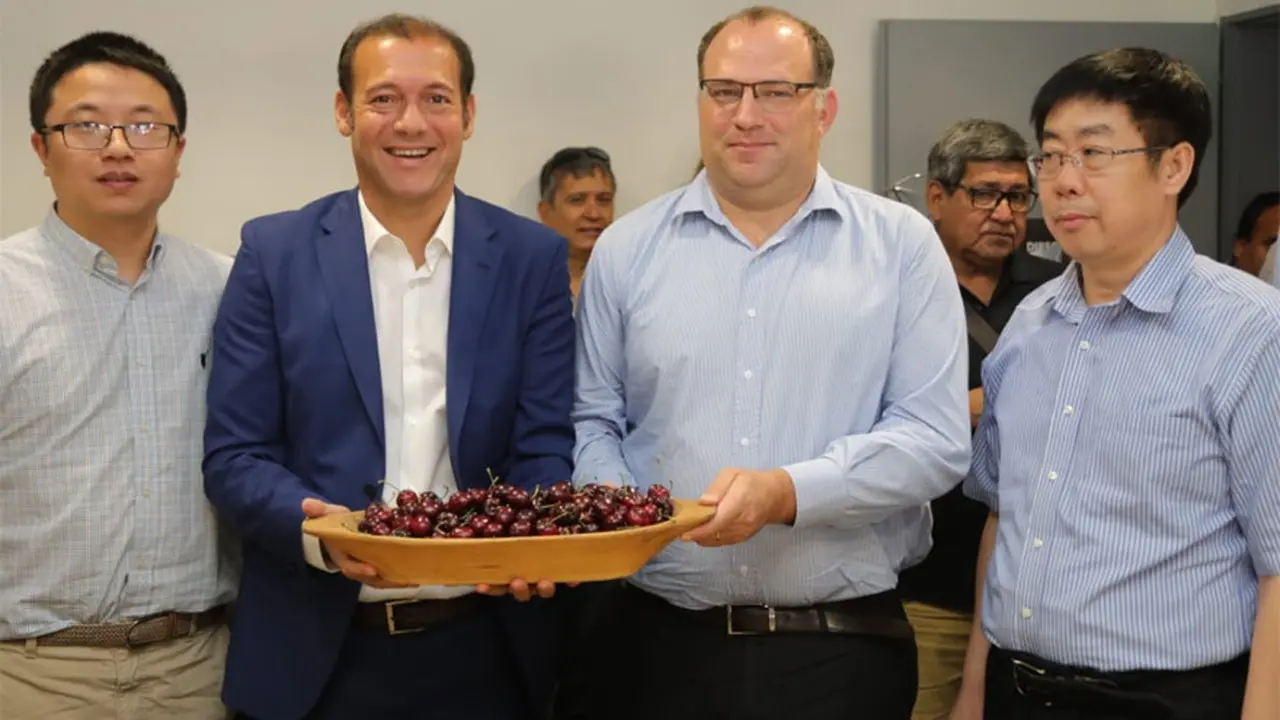 El gobernador de Neuquén, Omar Gutiérrez, sostiene cerezas.