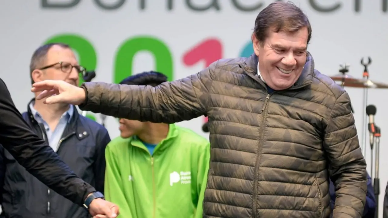 Guillermo Montenegro en un escenario con una campera y sonriendo