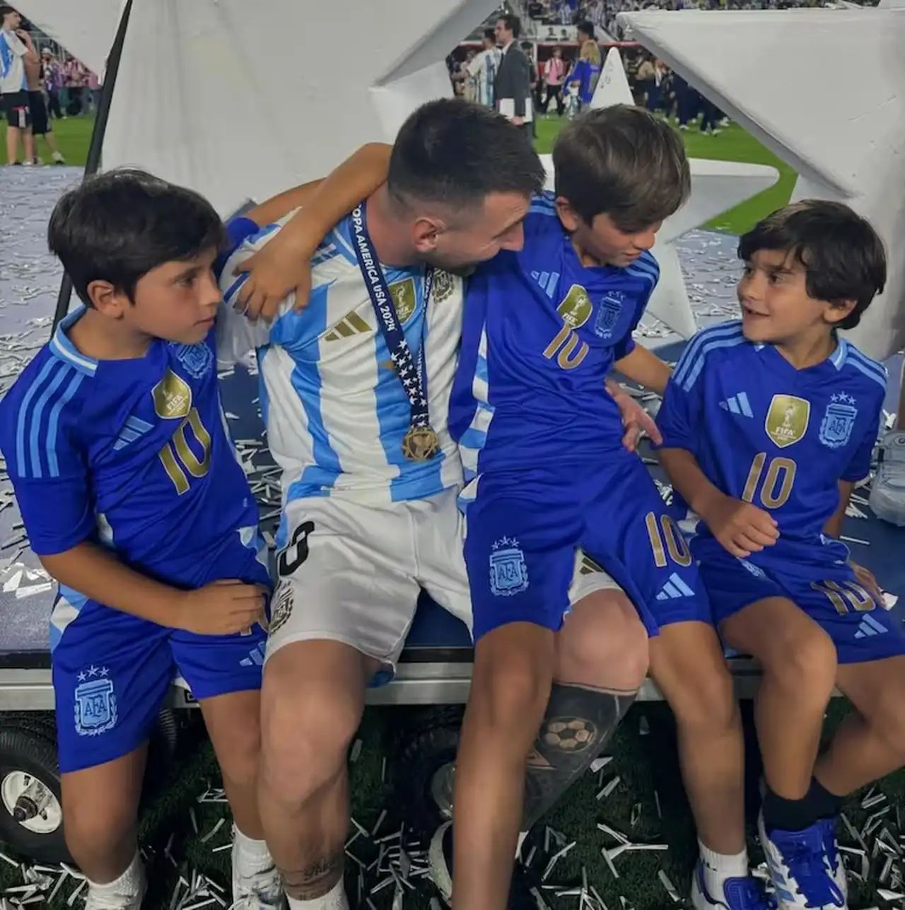 Messi sonriendo mientras miraba a Ciro, con Thiago y Mateo a su lado