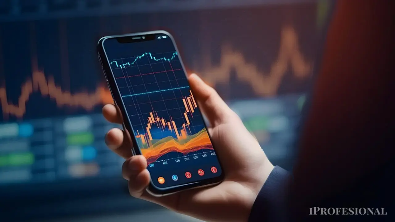 Un hombre con un celular en la mano en el que se ve una variable del mercado en crecimiento