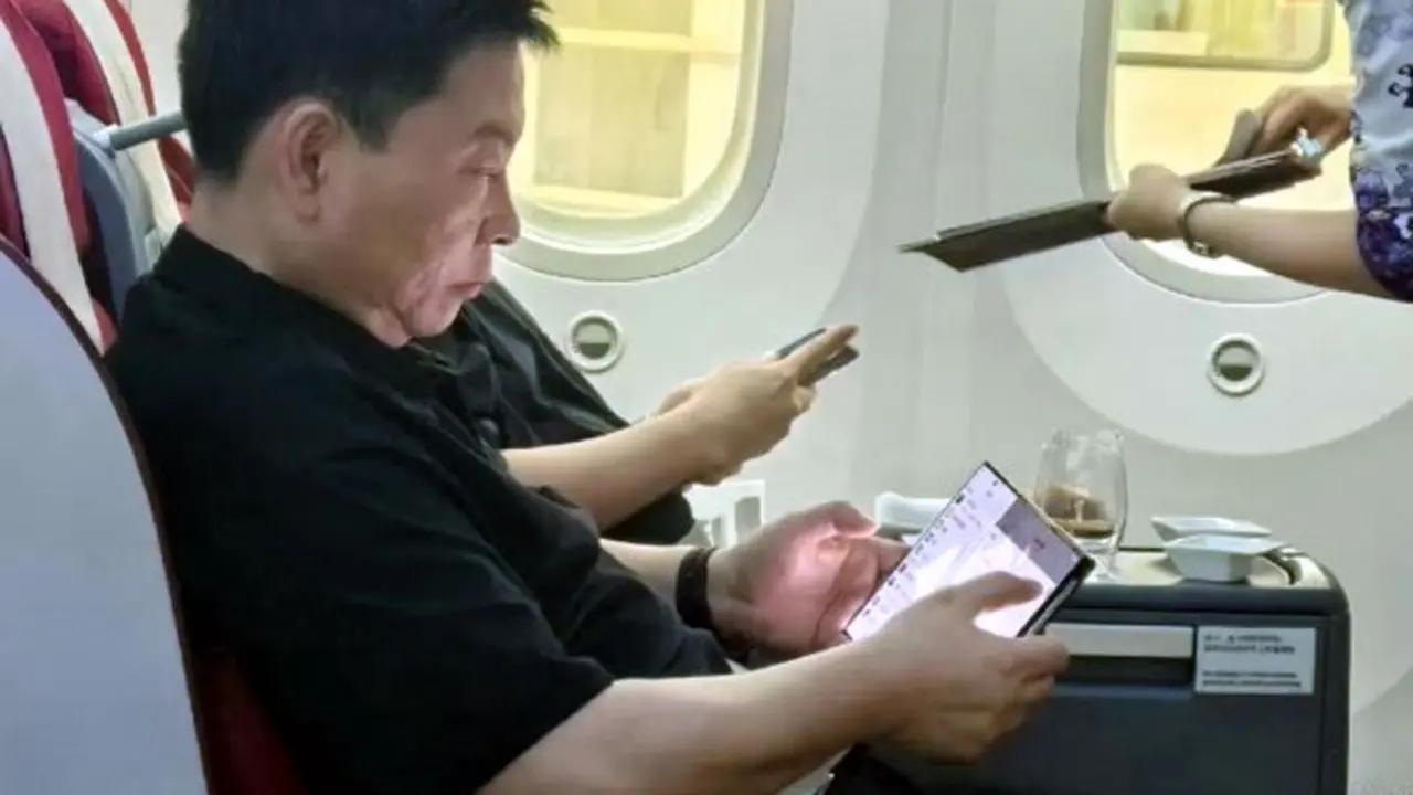 El jefe de dispositivos de consumo de Huawei, Yu Chengdong, con el celular de triple pantalla, en un avión en China.