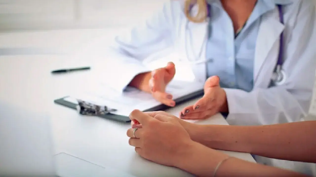 manos de medico sentado y gesticulando frente a paciente