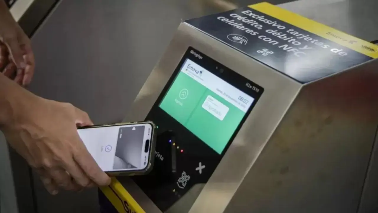 Un pasajero pagando el boleto de subte con su teléfono celular