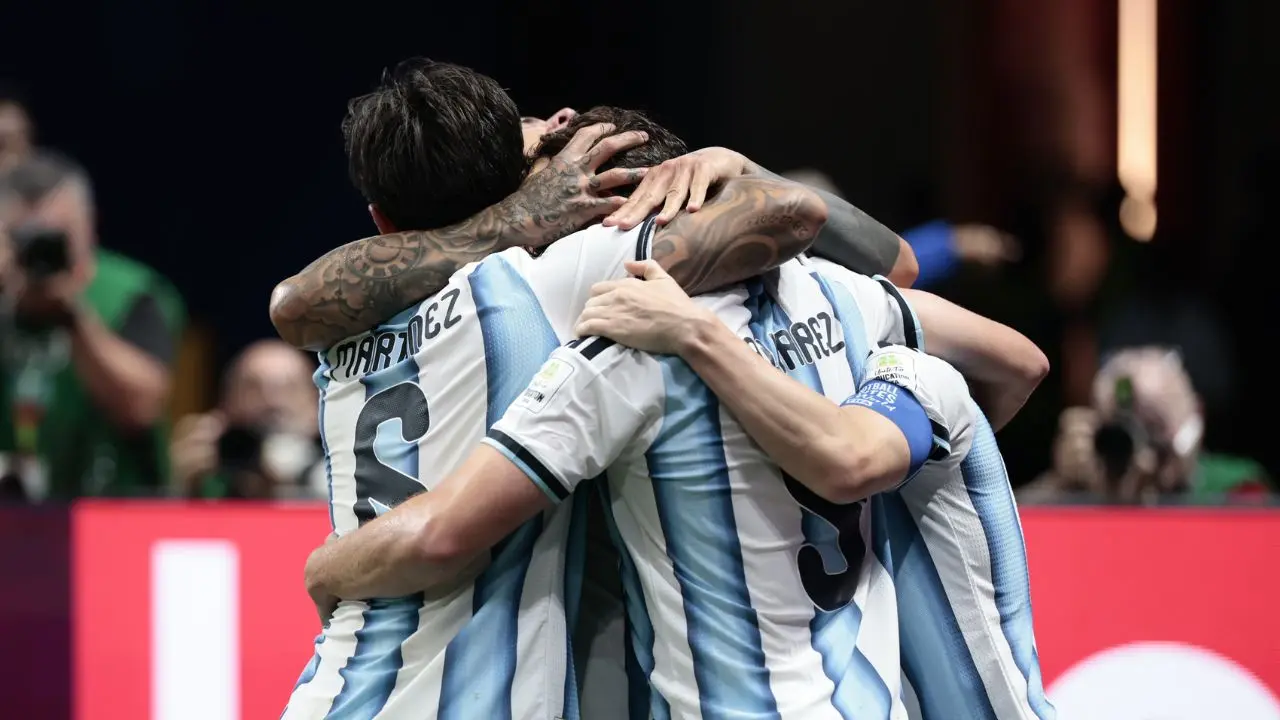 Unos jugadores de la Selección argentina abrazados tras hacer un gol en el campo de juego