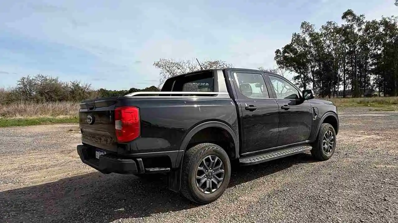 Ford Ranger Black de atrás y perfil sobre terreno de pierdas.