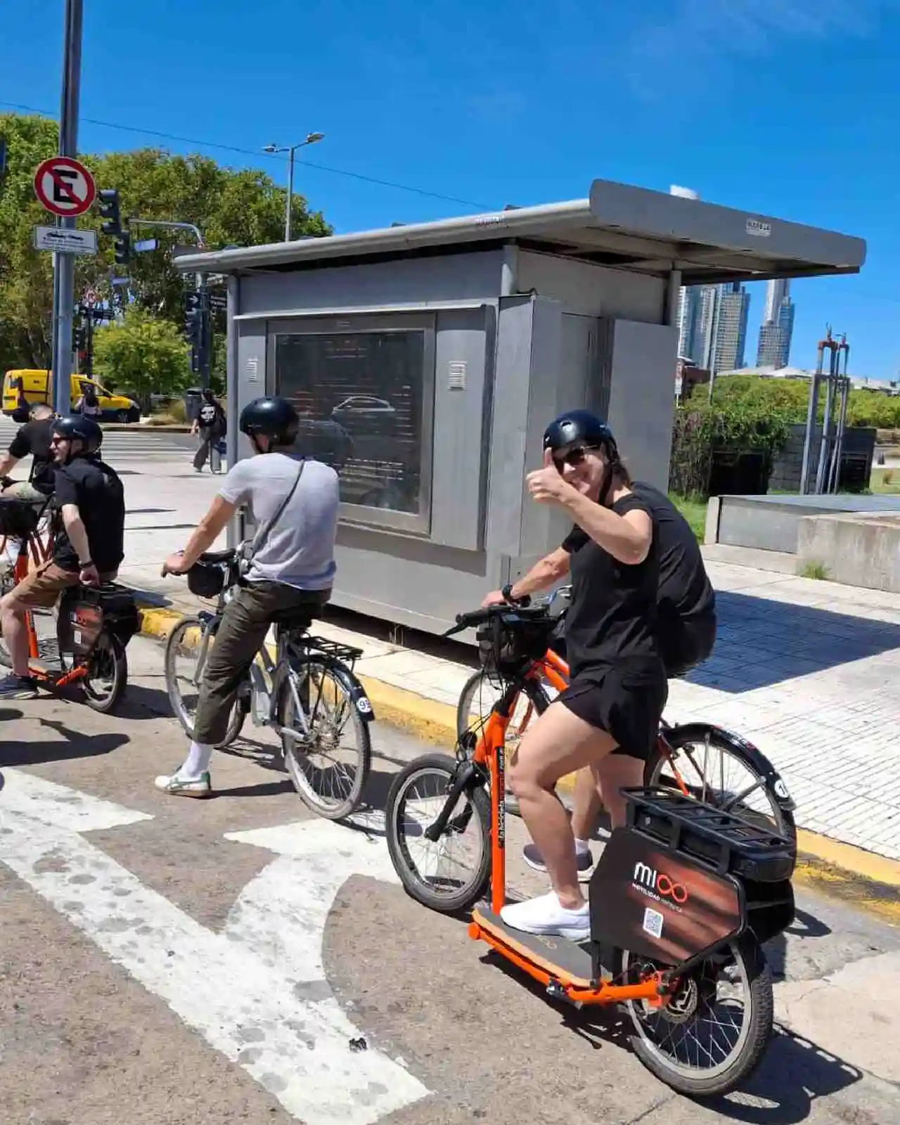 Un grupo de turistas disfrutando un  paseo por una avenida porteña en bicipatineta