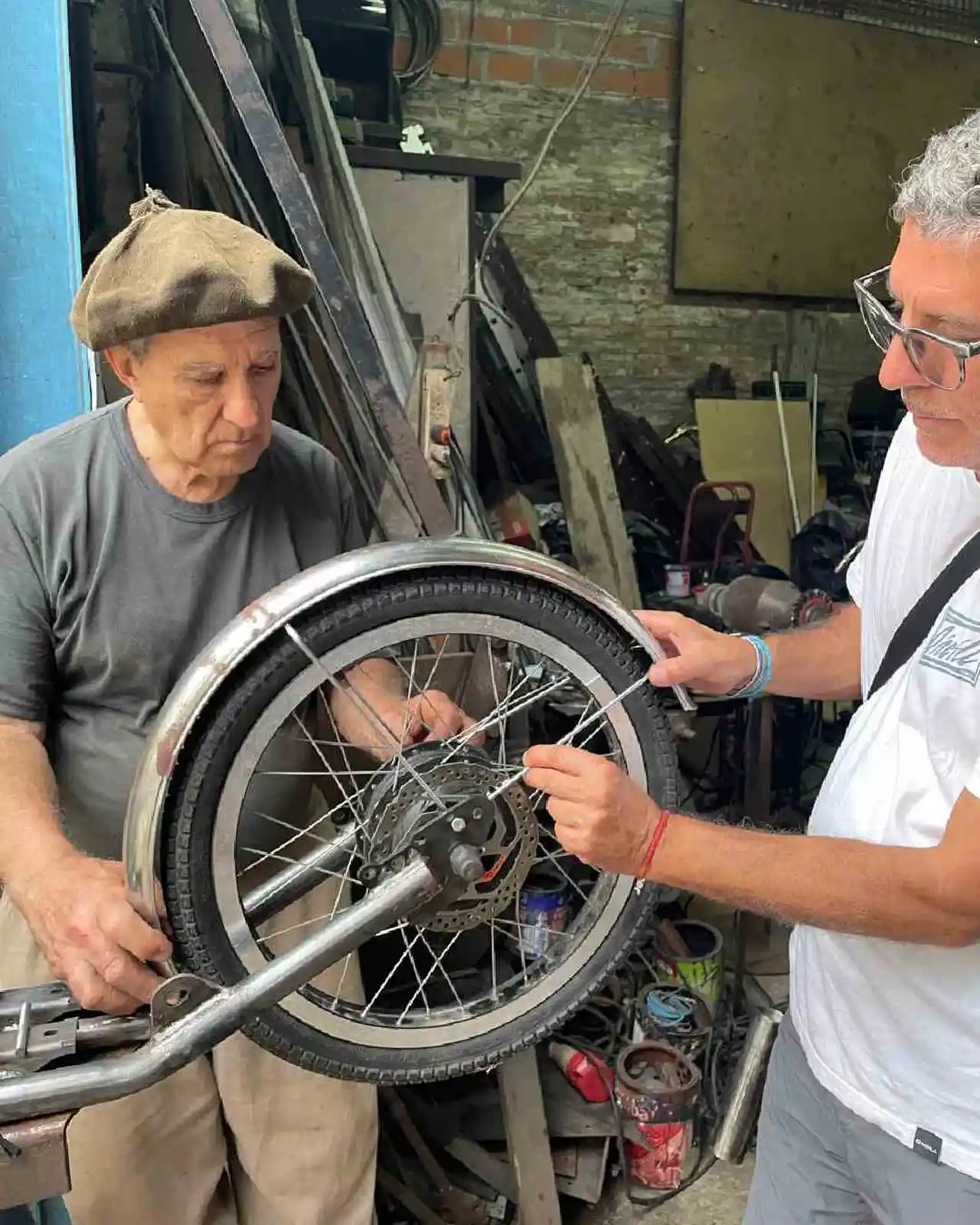 Dos hombres reparando la rueda de una bicipatineta