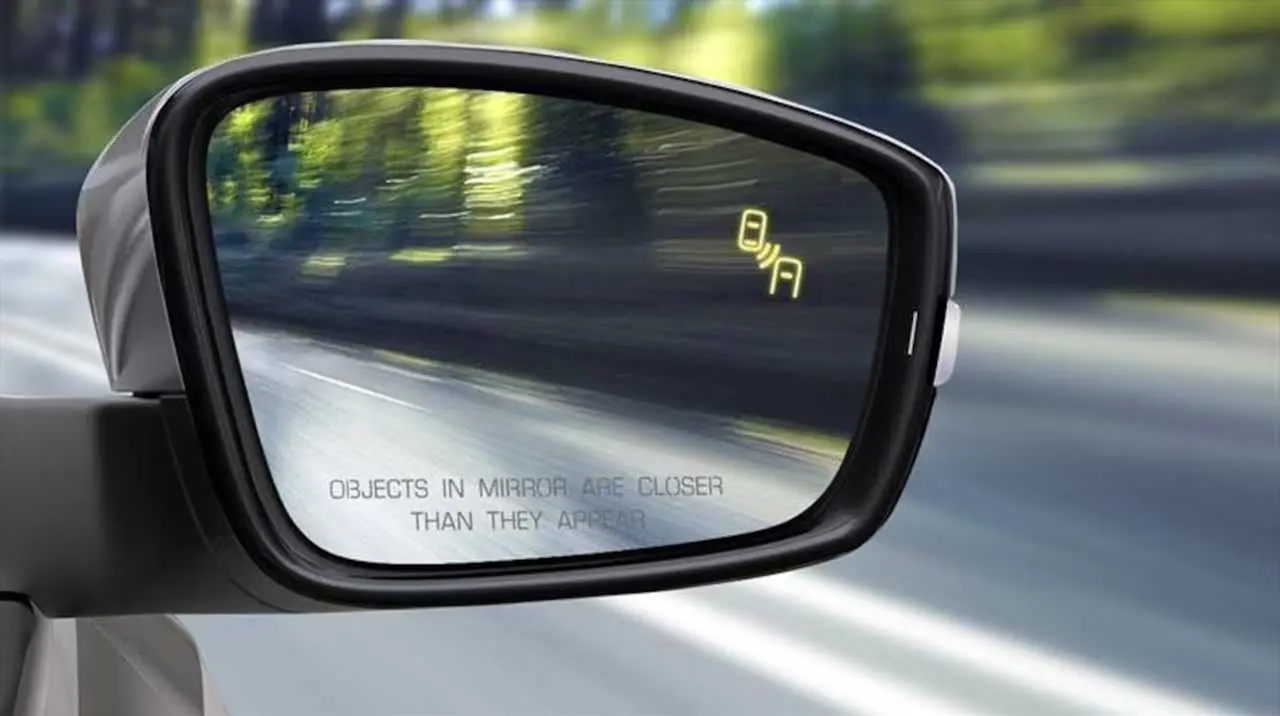 Espejo retrovisor de un auto con alerta luminosa del sistema de detección de punto ciego