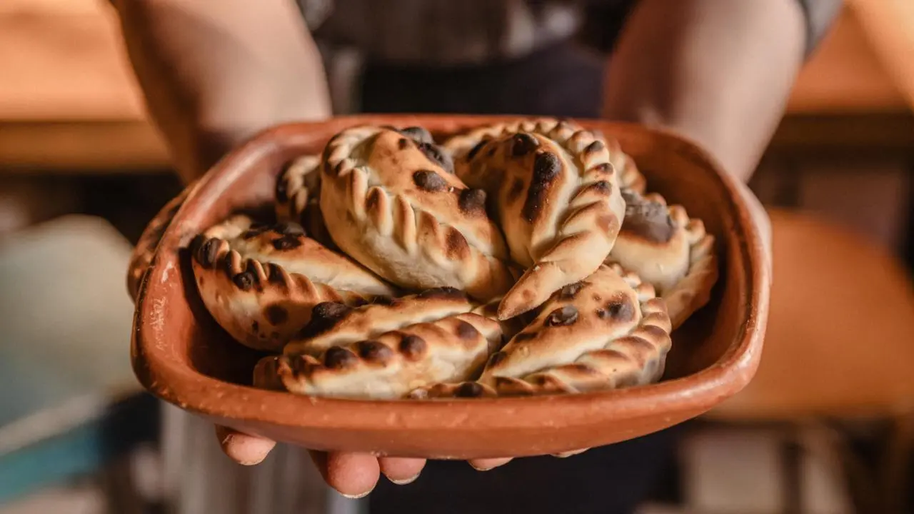 Plato de empanadas salteñas cocinadas en horno de leña con sus manchas negras características