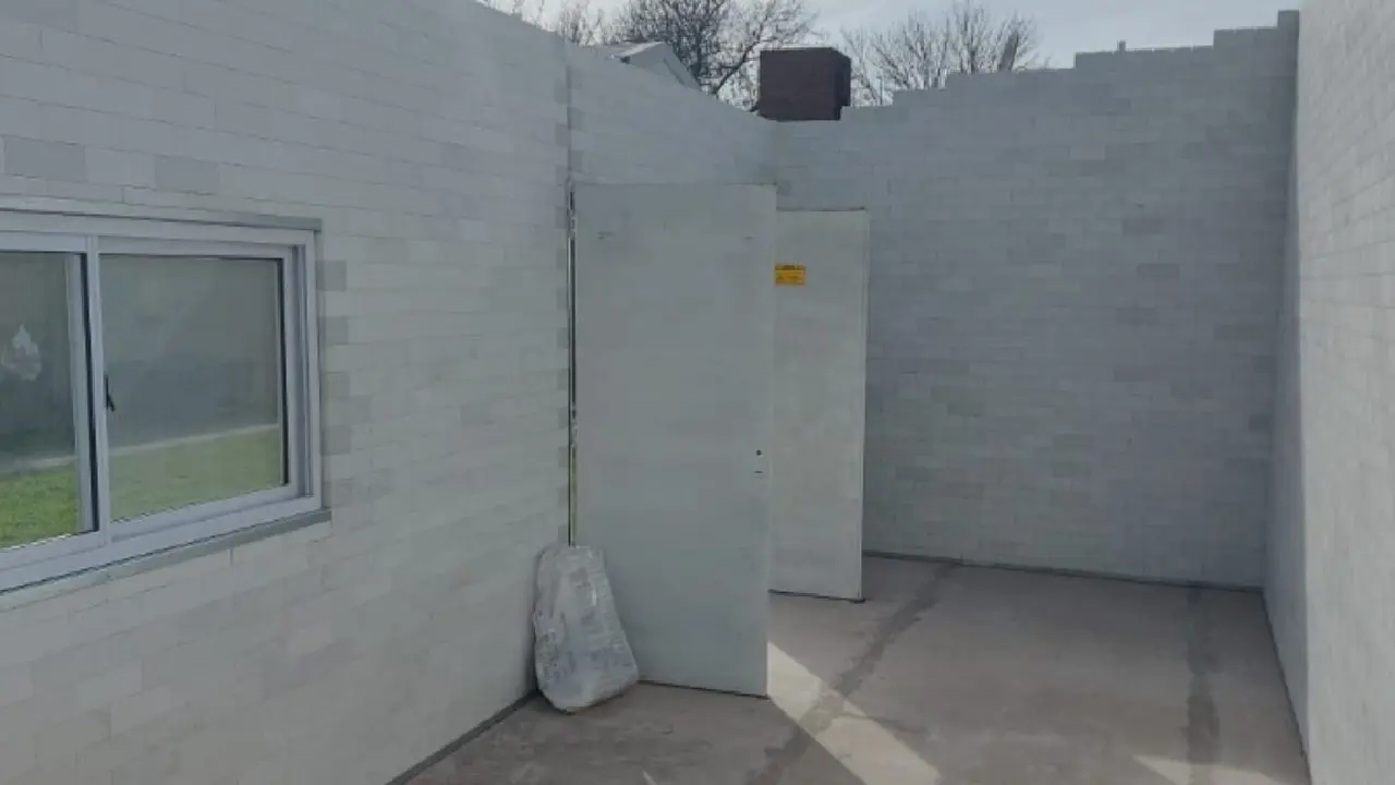 Paredes de una casa en construcción realizada con ladrillos sustentables de color blanco y una ventana 