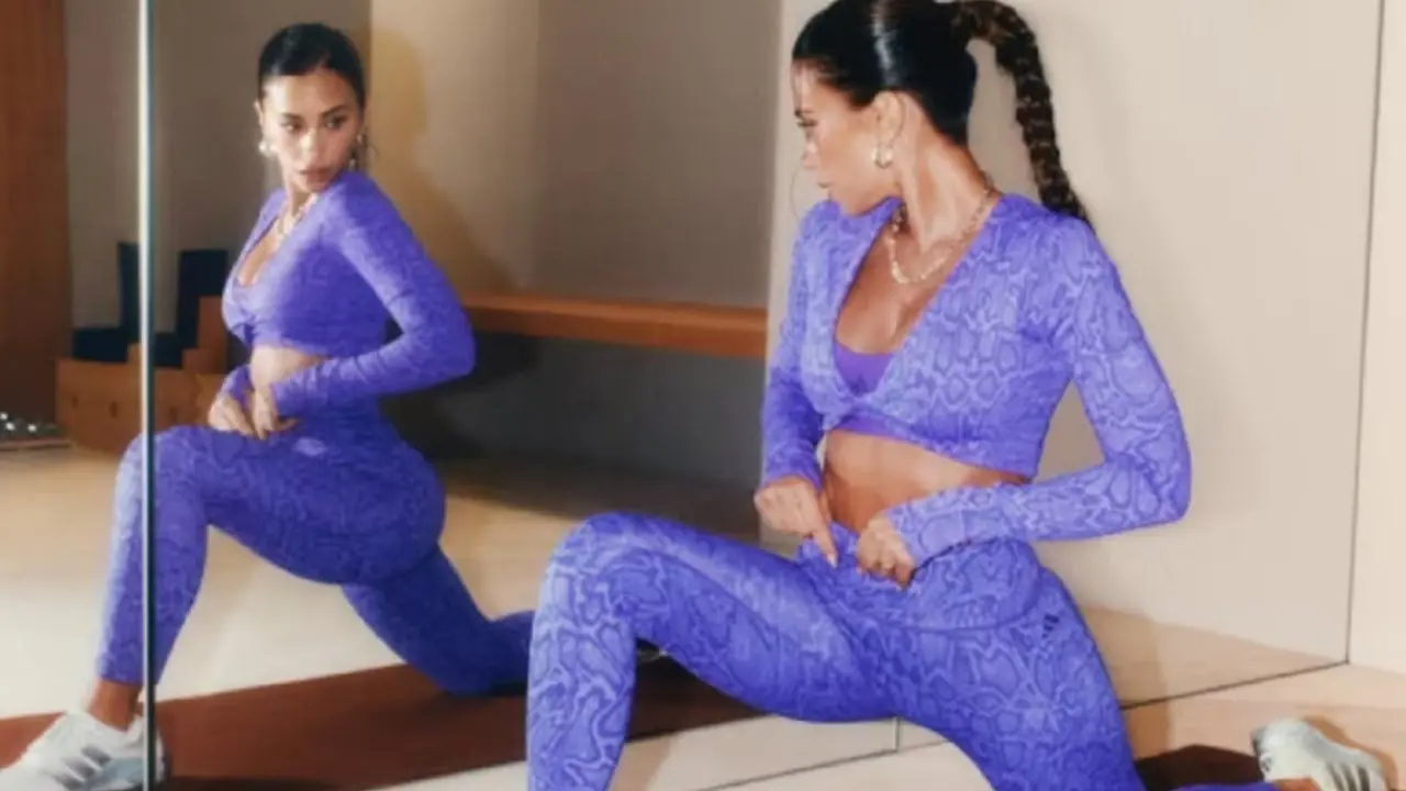 Antonela Roccuzzo con ropa deportiva arrodillada adelante de un espejo haciendo gimnasia