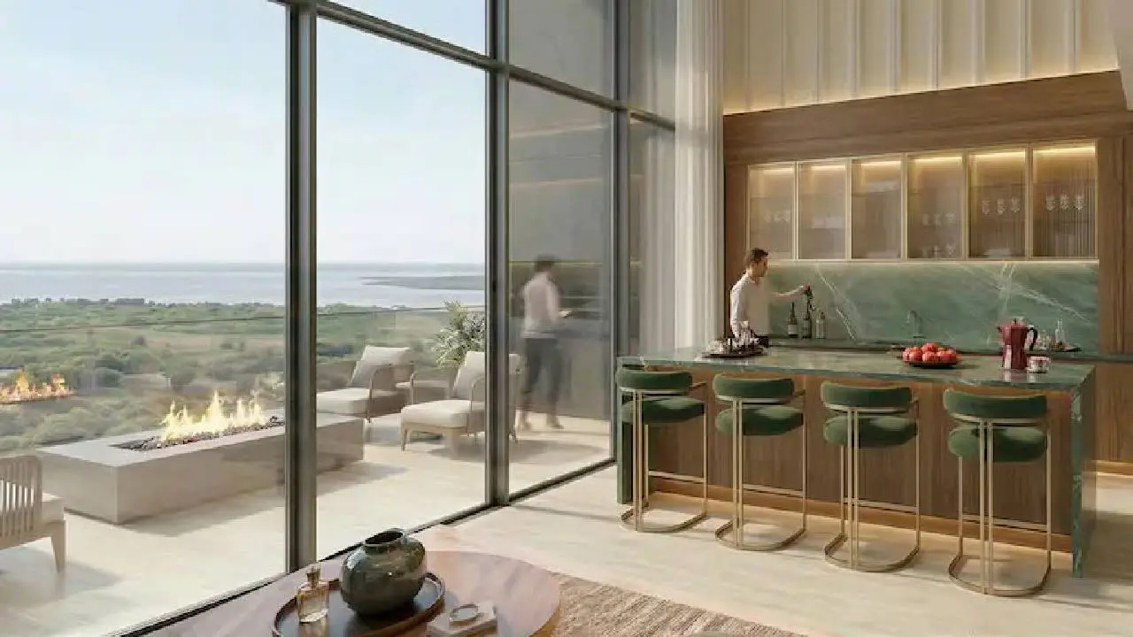 Espacio cerrado con barra, butacas y bebidas y una puerta transparente que conecta con el exterior