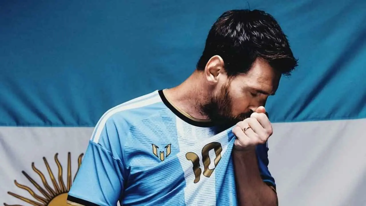messi besando su camiseta con bandera argentina detrás