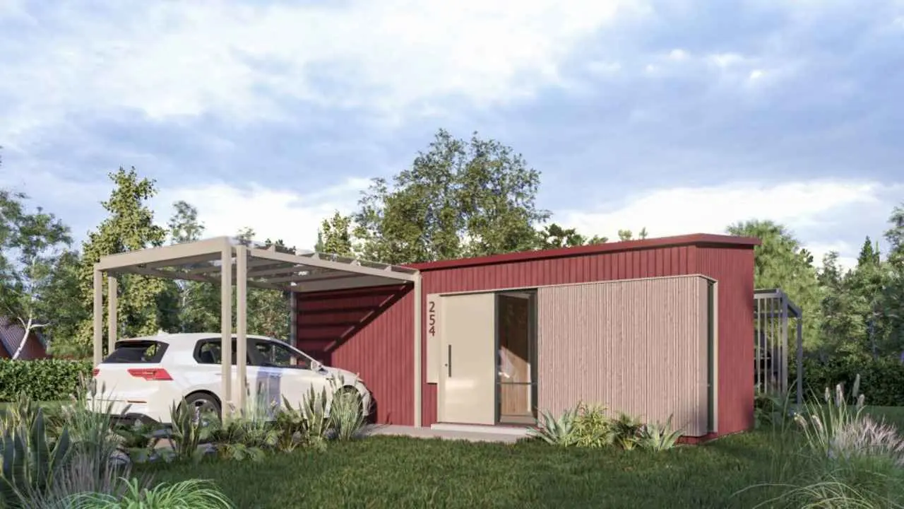 Imagen del exterior de una casa modular, con un auto estacionado en la puerta. Foto de archivo