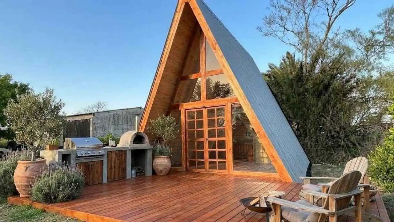Cabaña alpina de madera vista desde el frente sobre una base también de madera