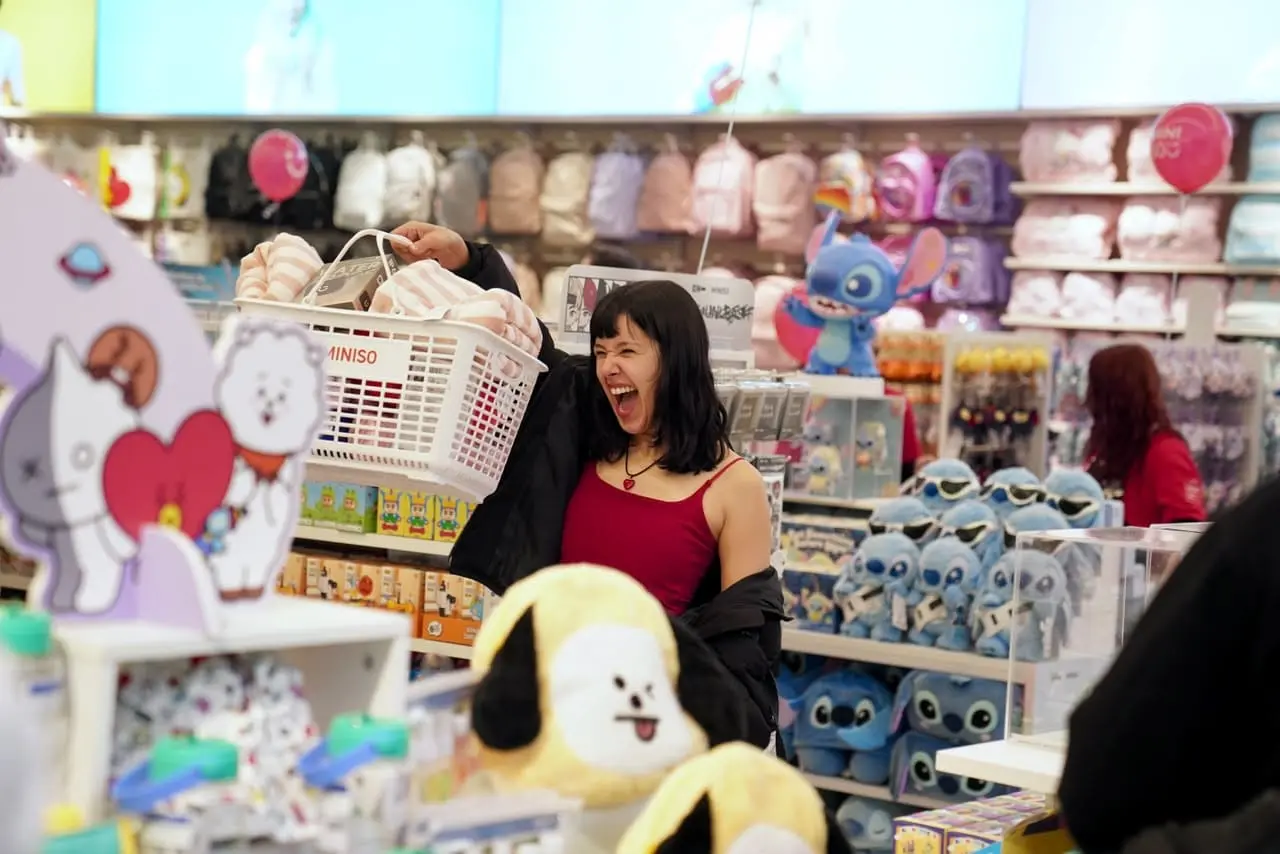 Mujer feliz comprando en local Miniso