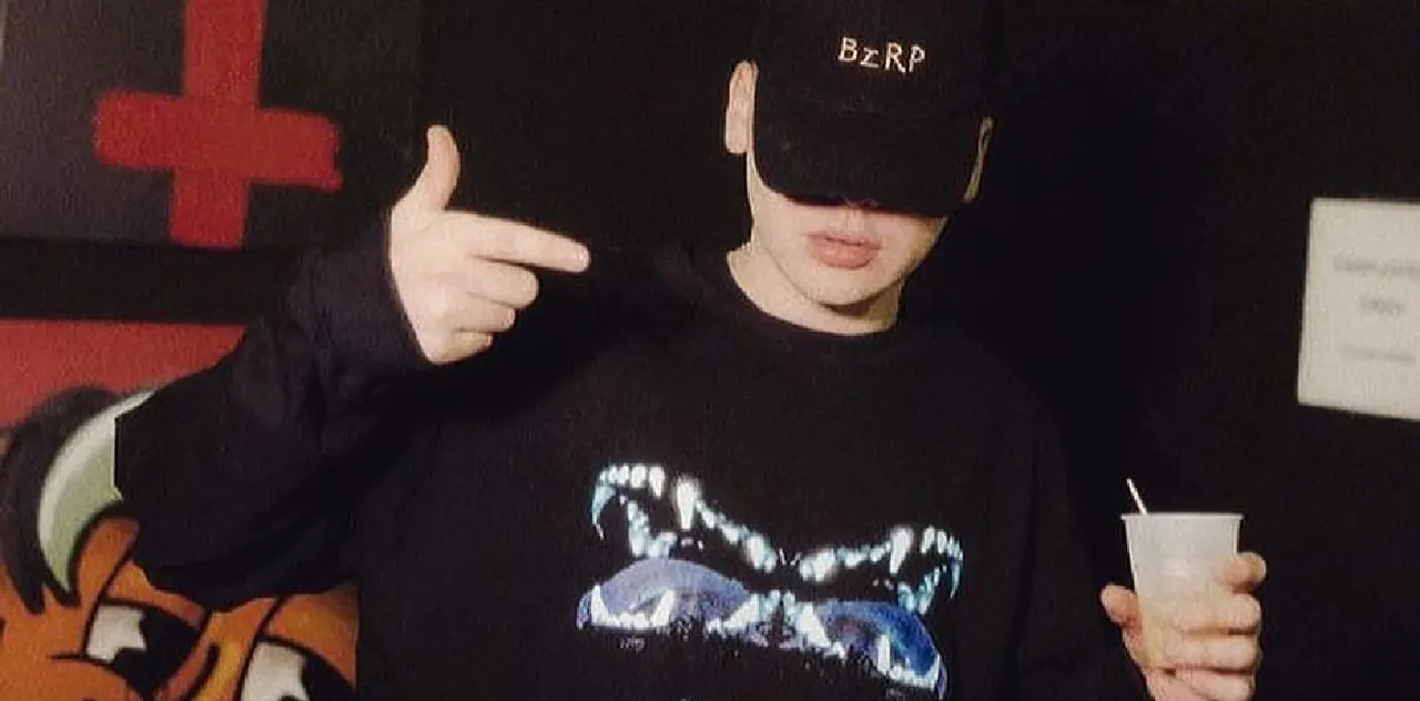El artista Bizarrap luciendo una gorra negra que le tapa la cara y un buzo negro de la marca Undefined
