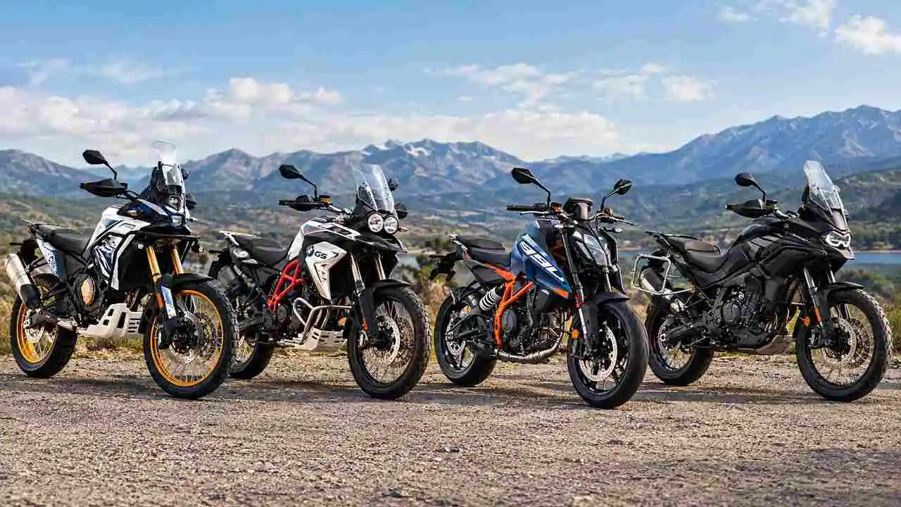 Cuatro motos estacionadas con un paisaje de montañas atrás