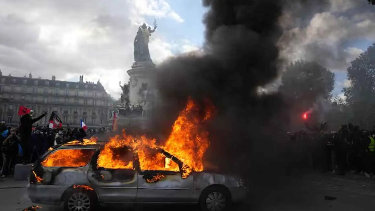 Un auto prendiéndose fuego en las calles de Paris en medio de una manifestación