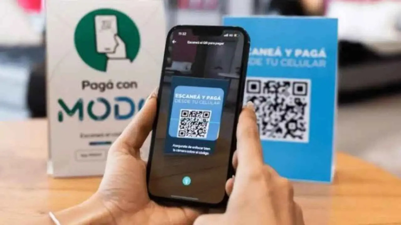 Un celular pagando en un comercio con código QR