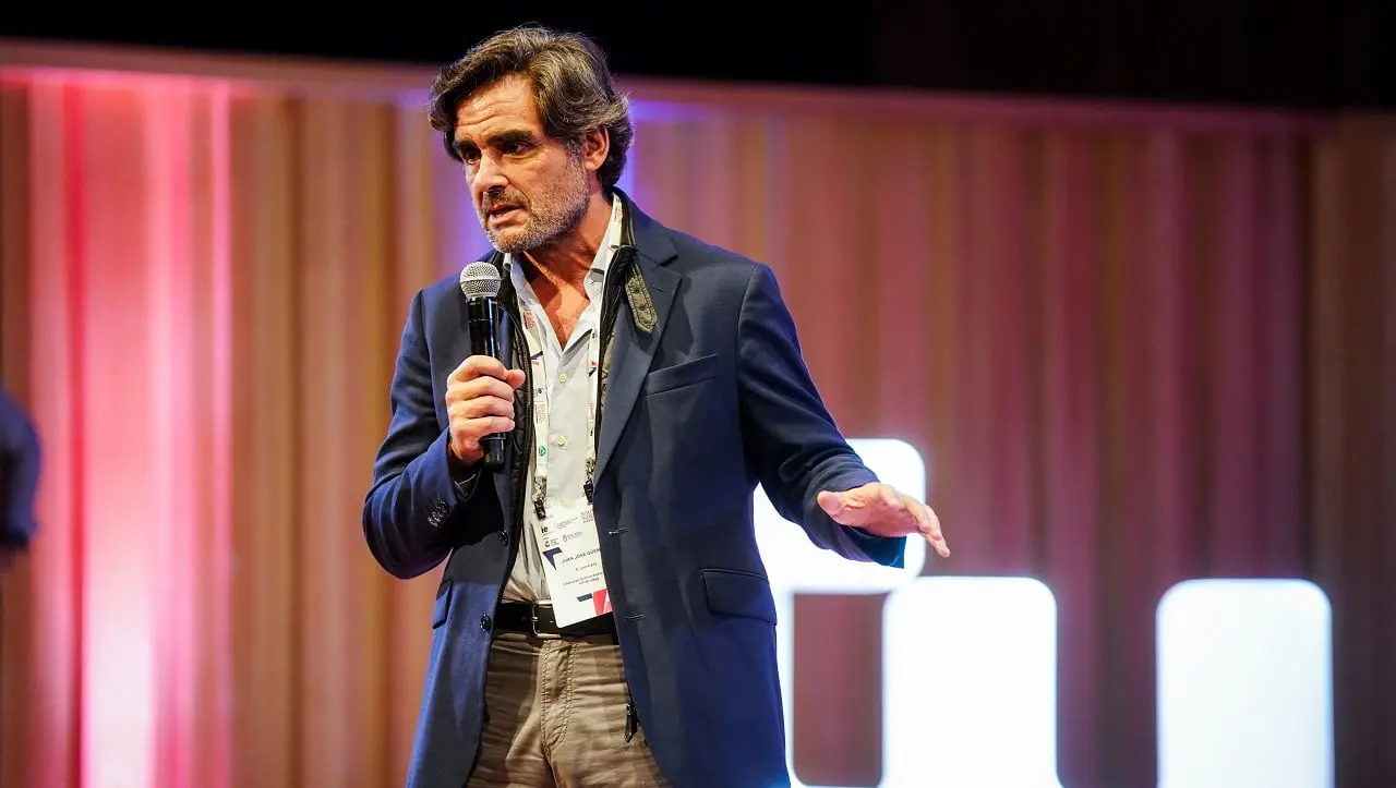 Juan José Güemes, presidente del Centro Internacional de Emprendimiento de IE University dando una conferencia con un micrófono en la mano