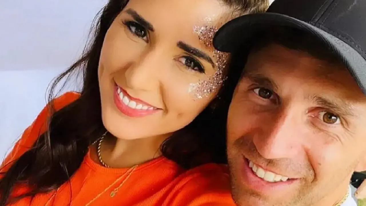 Los rostros de Dibu Martines y su esposa juntos sonriendole a la cámara