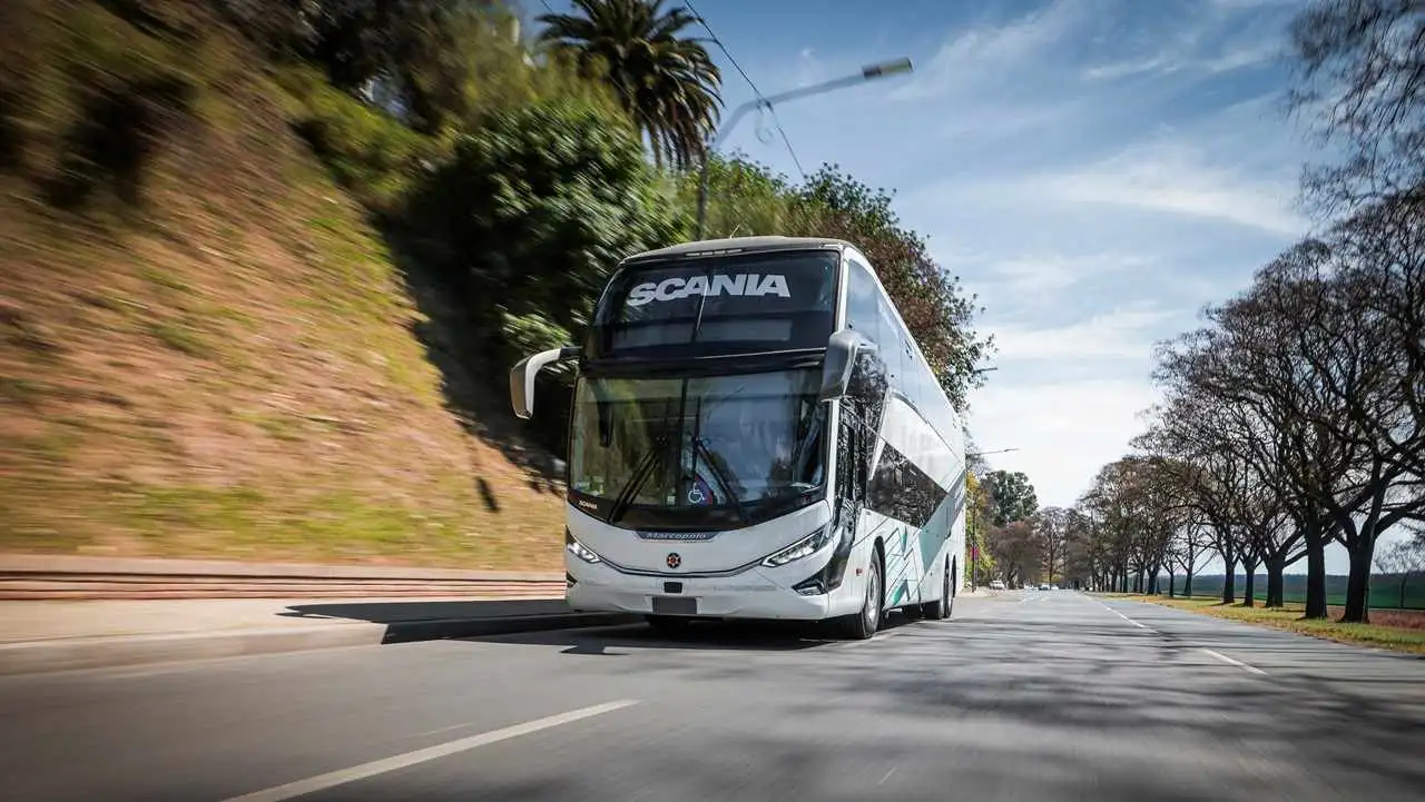 bus en la ruta de frente con cesped de fondo. foto oficial.