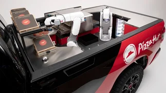 Pizza Hut presentó una camioneta con dos brazos robóticos que prepara sus propias pizzas