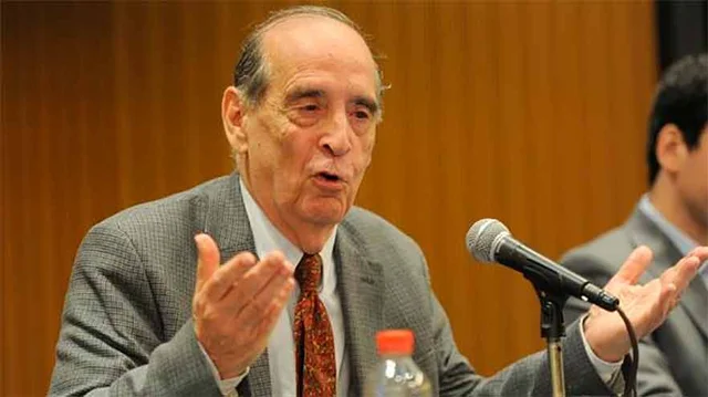 Economista Ricardo Arriazu dando una conferencia delante de un micrófono. Imagen de archivo