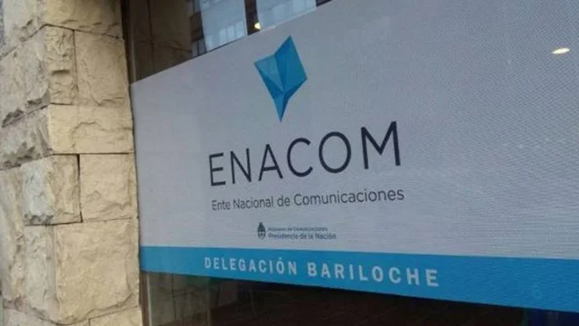 Una puerta de vidrio ploteada con el logo del ENACOM