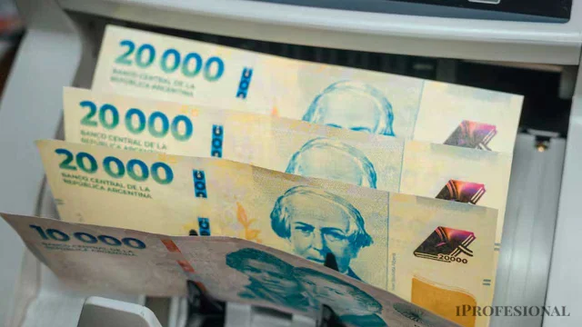 Un cajero automático entregando billetes de 20 mil pesos