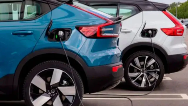 Dos autos eléctricos cargándose en un estacionamiento