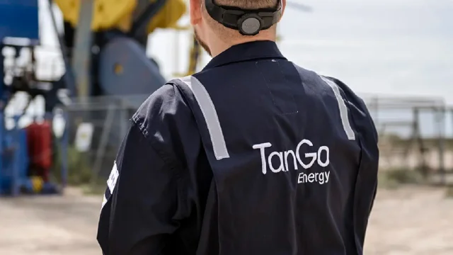 Operario de Tango Energy parado frente a un pozo petrolero de Vaca Muerta. Imagen de archivo