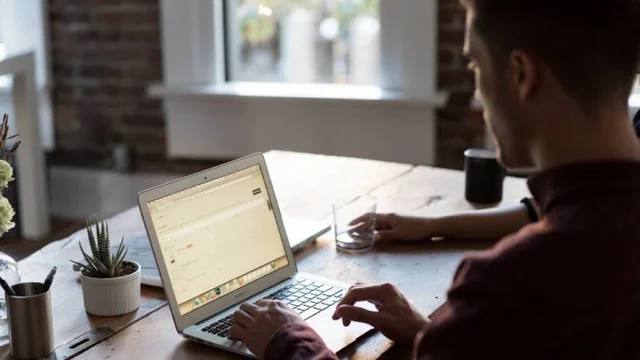 joven trabaja con una computadora desde su hogar