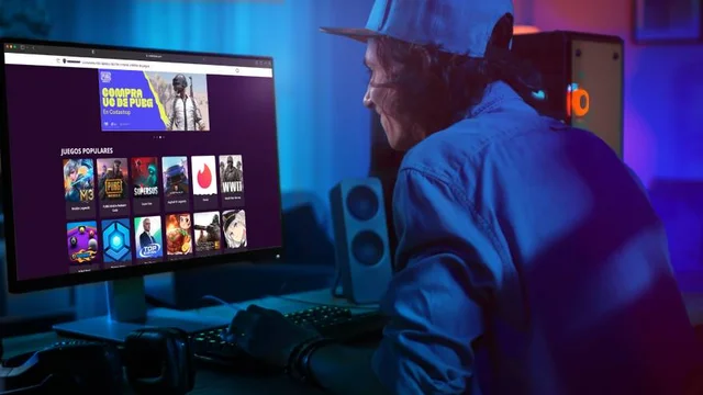 usuario con gorra sentando frente a la computadora, que muestra títulos de videojuegos en su pantalla