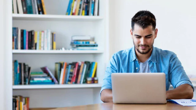 joven mirando una computadora portátil en posición de estudio