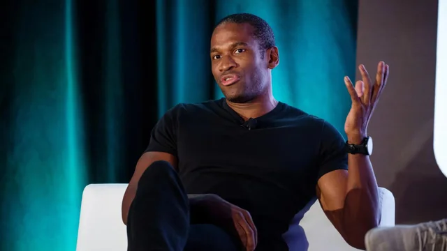 Arthur Hayes sentado, hablando y gesticulando durante una entrevista