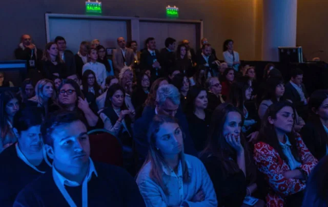 Grupo de personas atentas en un auditorio