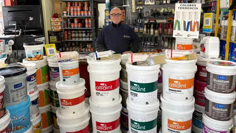 Guillermo Ortega de Sui Color en el local rodeado de latas de pintura All Paint, su propia marca