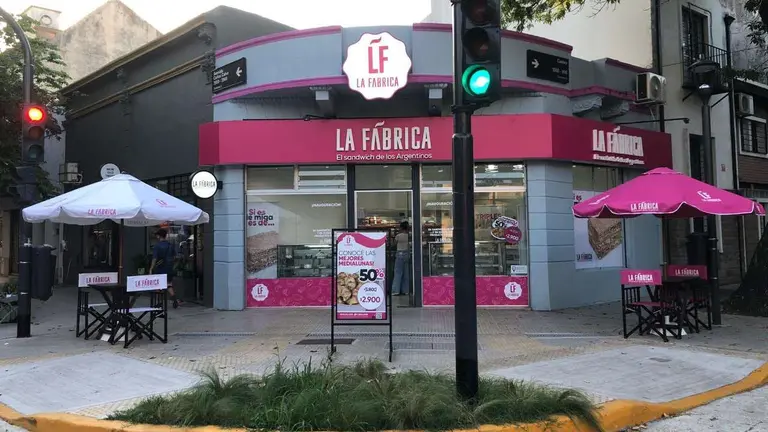 Frente de un local de La Fábrica en una esquina con un semáforo adelante