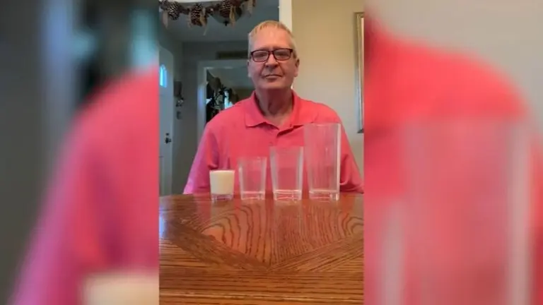 Este hombre llena un vaso grande con la cantidad de leche que cabe en uno pequeño