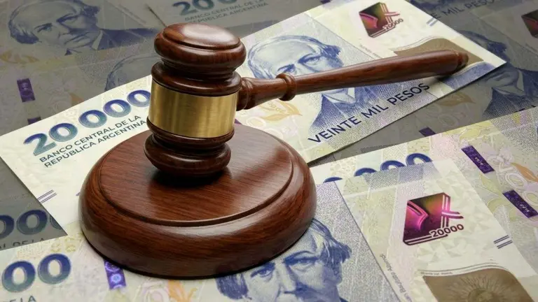 Un mazo de juez, con billetes de pesos de fondo. Imagen generada por iProfesional