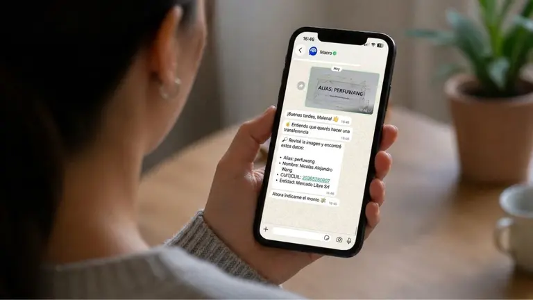 pantalla de celular con imagen de Macrochat sostenida con una mano por mujer joven. Imagen generada por IA