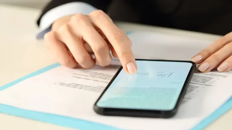 Una persona realizando una firma digital en el celular