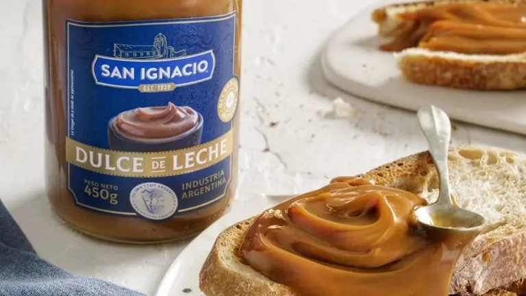 Un pote de dulce de leche, tostadas y una cuchara